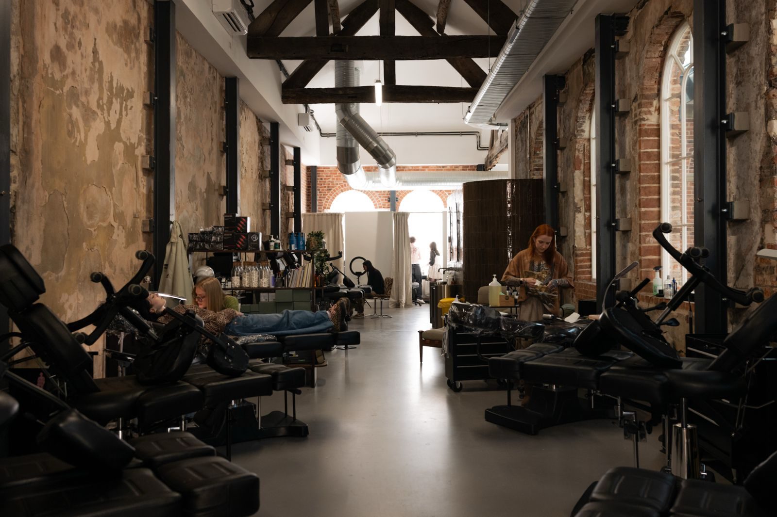 First White Cloth Hall — tattoo studio interior with exposed plaster and arched windows